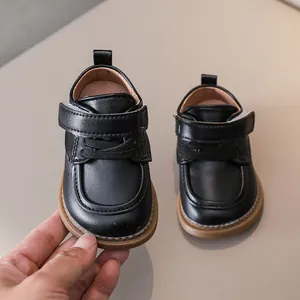 Close-up of black PU leather baby shoes with velcro closure and non-slip rubber soles