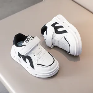 Détail de baskets blanches pour enfants avec bordure noire et bande velcro