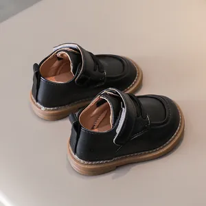 Overhead view of black leather toddler shoes with gum soles and velcro straps