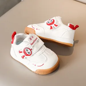 Dettaglio di sneakers bianche per bambini con patch robot rosso e suola in gomma antiscivolo