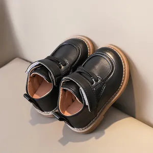 Detail view of toddler black leather shoes with anti-slip rubber soles and velcro straps