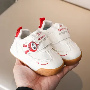 Dettaglio scarpa sportiva per bambini in pelle bianca con cuciture rosse e velcro