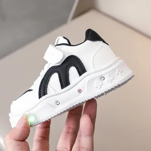 Vue détaillée des baskets LED blanches pour enfants avec lumière verte et velcro