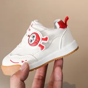 Dettaglio di sneaker bianca per bimbi con motivo rosso e suola in gomma antiscivolo