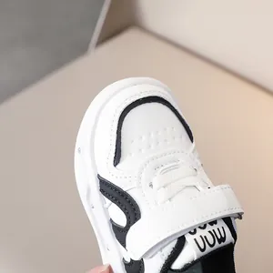 Détails des baskets pour enfants en blanc avec contrastes noirs et fermeture velcro