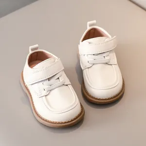 Detail view of cream toddler shoes featuring adjustable velcro straps and anti-slip rubber soles