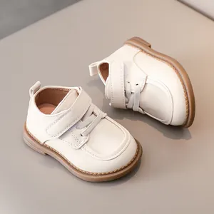 Close-up of non-slip rubber sole and stitching on cream leather toddler shoes