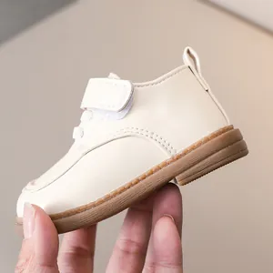 Close-up of beige leather baby shoes with velcro straps and anti-slip rubber soles