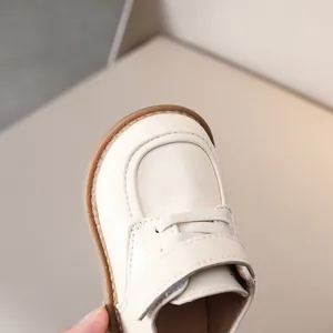 Close-up of baby beige leather shoes showing soft texture and round toe detail