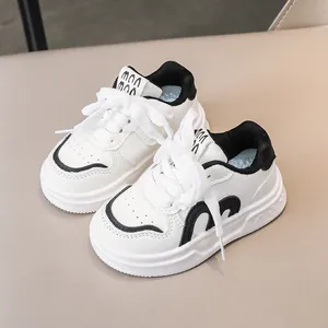 Klassische schwarz-weiße Kinder-Sneaker mit weicher Sohle und modischem Schriftzug