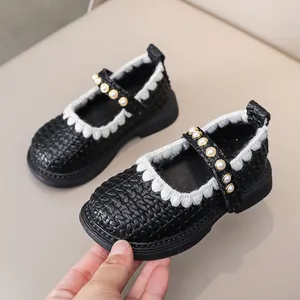 Detail von schwarzen Mädchen Mary Jane Schuhen mit Perlenriemen und Spitzenbesatz