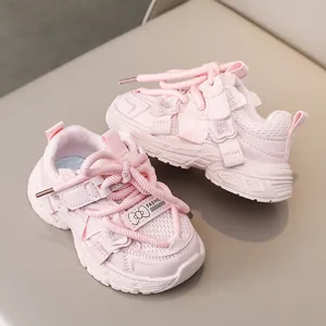 Detail of pink girls sports shoe showing mesh fabric, velcro strap and butterfly accent