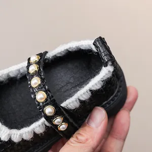 Detail von Mary Jane Schuhen für Mädchen mit Perlenriemen und weißem Häkelrand