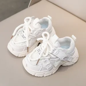Close-up of white girls' sneakers featuring mesh fabric, bow details, and wavy chunky soles