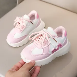 Detail of pink and white children sneaker with leather upper and velcro strap closure