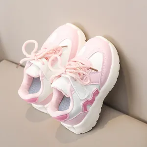 Detailed side view of pink and white children sports shoes with non-slip thick soles