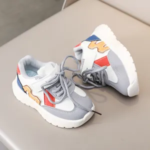 Detail of children sneakers with orange wave overlay and non-slip rubber soles