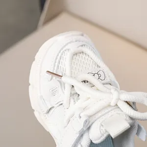 Macro detail of kids white chunky sneakers showing breathable mesh and butterfly pattern