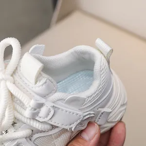 Detail of white kids sneakers showing breathable mesh lining and secure velcro strap