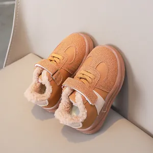 Macro della fodera in pile e del materiale scamosciato sulle scarpe da bimbo