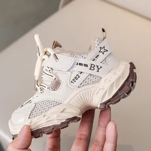 Detail of kids breathable mesh sneaker featuring beige leather panels and 1982 text