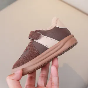 Dettaglio di scarpe marroni foderate in pile per bambini con chiusura a strappo antiscivolo