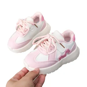 Pink and white leather kids sneakers with lace-up and velcro closure on white background
