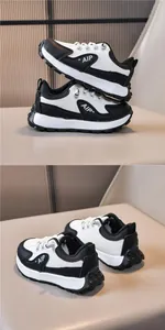 Dettaglio di sneaker per bambini in bianco e nero con logo AIP e suola in gomma dentata