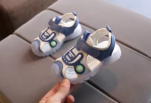 Close-up of kids closed-toe sports sandals with blue mesh, spider icons and velcro strap