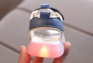 Detail of LED light-up sole on kids' mesh athletic sandals with glowing pink translucent rubber