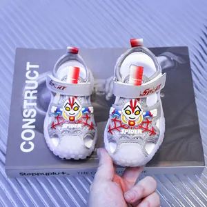 Detail view of gray kids closed-toe sandals with mesh fabric and red spider patterns