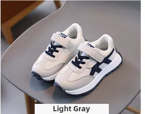 Close-up of light grey kids sports sneakers with breathable mesh and velcro straps