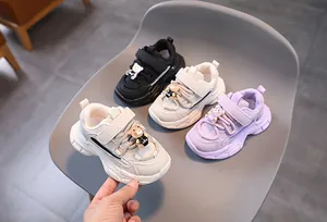 Détail de baskets pour enfants avec breloque ours mignonne et fermeture velcro durable