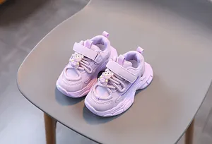 Détail de baskets violettes pour enfants avec un ours 3D sur la bride velcro