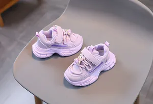 Détail de baskets violettes pour enfants avec velcro et un ornement d'ours en 3D