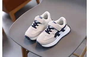 Detail of kids athletic shoes with breathable mesh and navy blue velcro closure