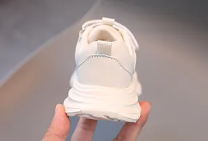 Détail de la semelle épaisse blanche et de la languette au talon des baskets en cuir enfant
