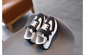 Detail view of children's breathable black and white retro sneakers with velcro closure