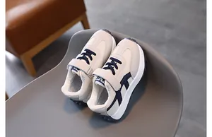 Macro detail of breathable cream and navy mesh kids sneakers with secure velcro strap
