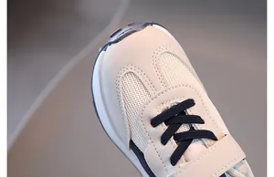 Macro view of mesh and synthetic leather panels on breathable children athletic sneakers