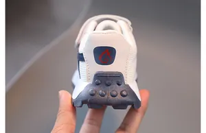 Detailed close-up of kids sports sneakers showing non-slip rubber soles and breathable mesh
