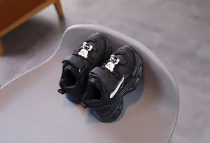 Détail de baskets noires pour enfants avec ours 3D et fermeture velcro pratique