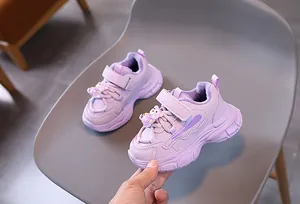 Détail de baskets violet clair pour enfants avec semelle épaisse antidérapante et breloque ours