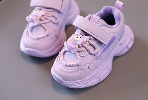 Détail de baskets violettes pour filles avec doublure en peluche et breloque ours