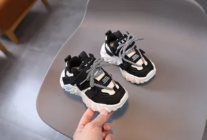 Detailed close-up of kids black and white dad sneakers with thick anti-slip rubber soles