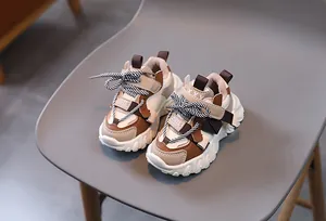 Detailed view of kids' fashion sneakers with thick soles and brown patchwork accents