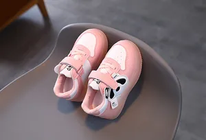 Close-up of pink and white kids' sneakers featuring a cute panda patch and Velcro strap