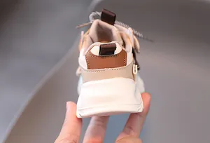 Detailed rear view of kids chunky sneaker featuring beige leather panels and thick sole