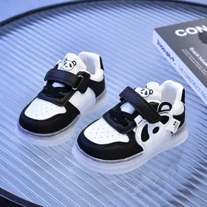 Detail of baby panda sneakers featuring velcro straps and breathable toe box on blue glass