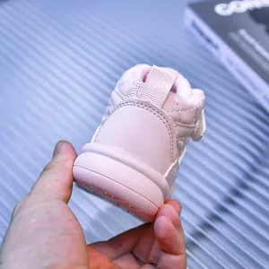 Dettaglio di stivaletti da neve rosa trapuntati con velcro e linguetta sul tallone